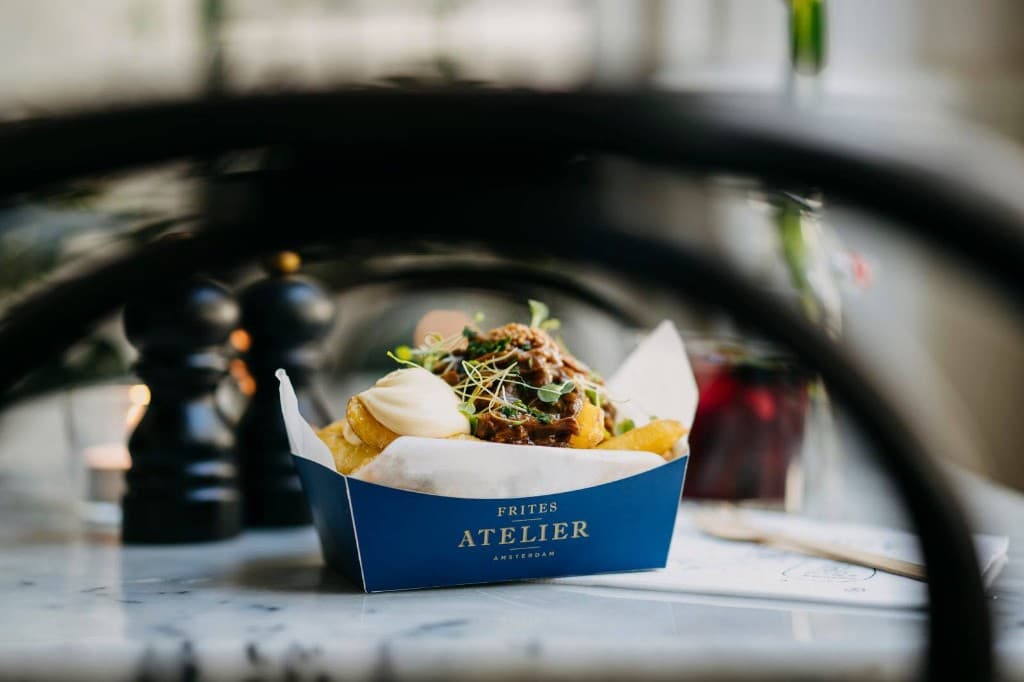 Frites Atelier branded fries packaging in use