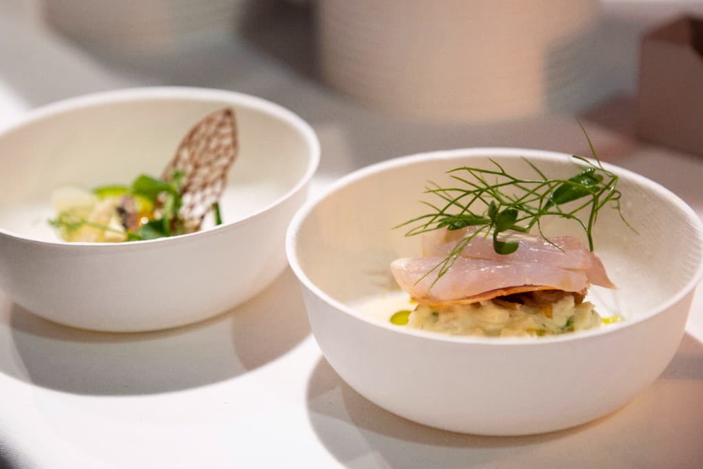 Soup served in a paper cup with sesame and herbs
