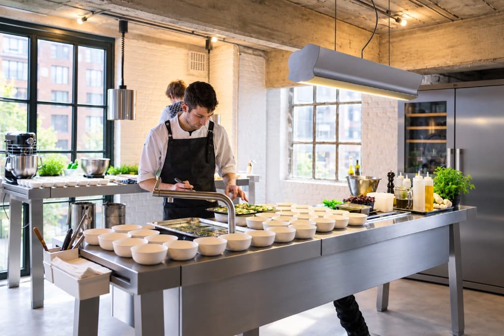 Chefs preparing dishes with renewable bowls in a professional kitchen